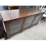 AN EARLY TWENTIETH CENTURY LOW MAHOGANY THREE DOOR CABINET ON BRACKET FEET