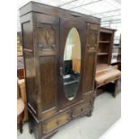 AN OAK WARDROBE WITH OVAL BEVEL EDGE MIRRORED DOOR AND TWO DRAWERS