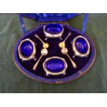 A HALLMARKED 1896 LONDON SILVER CASED SET OF FOUR SILVER SALTS WITH BLUE GLASS LINERS AND SPOONS -