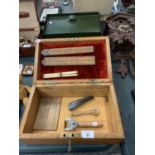 AN OLD WOODEN BOX (WITH KEY) INCLUDING THREE VINTAGE RULERS, VINTAGE TYLERS BOOTS SHOE HORN. FURTHER