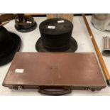 AN AUSTIN REED TOP HAT TOGETHER WITH A SMALL VINTAGE LEATHER SUITCASE