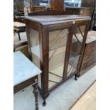 AN OAK CHINA CABINET ON CABRIOLE SUPPORTS WITH TWO GLAZED DOORS, GLAZED SIDES AND SHELVES