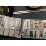 AN ALBUM CONTAINING A LARGE QUANTITY OF CIGARETTE CARDS