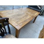 A LARGE OAK EXTENDING DINING TABLE