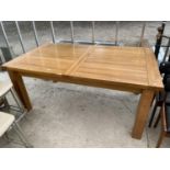 A LARGE OAK EXTENDING DINING TABLE