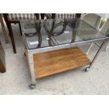 A CHROME AND ROSEWOOD EFFECT GLASS TOPPED TEA TROLLEY