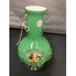 A GREEN GLASS VASE WITH ORNATE FLOWER DESIGN