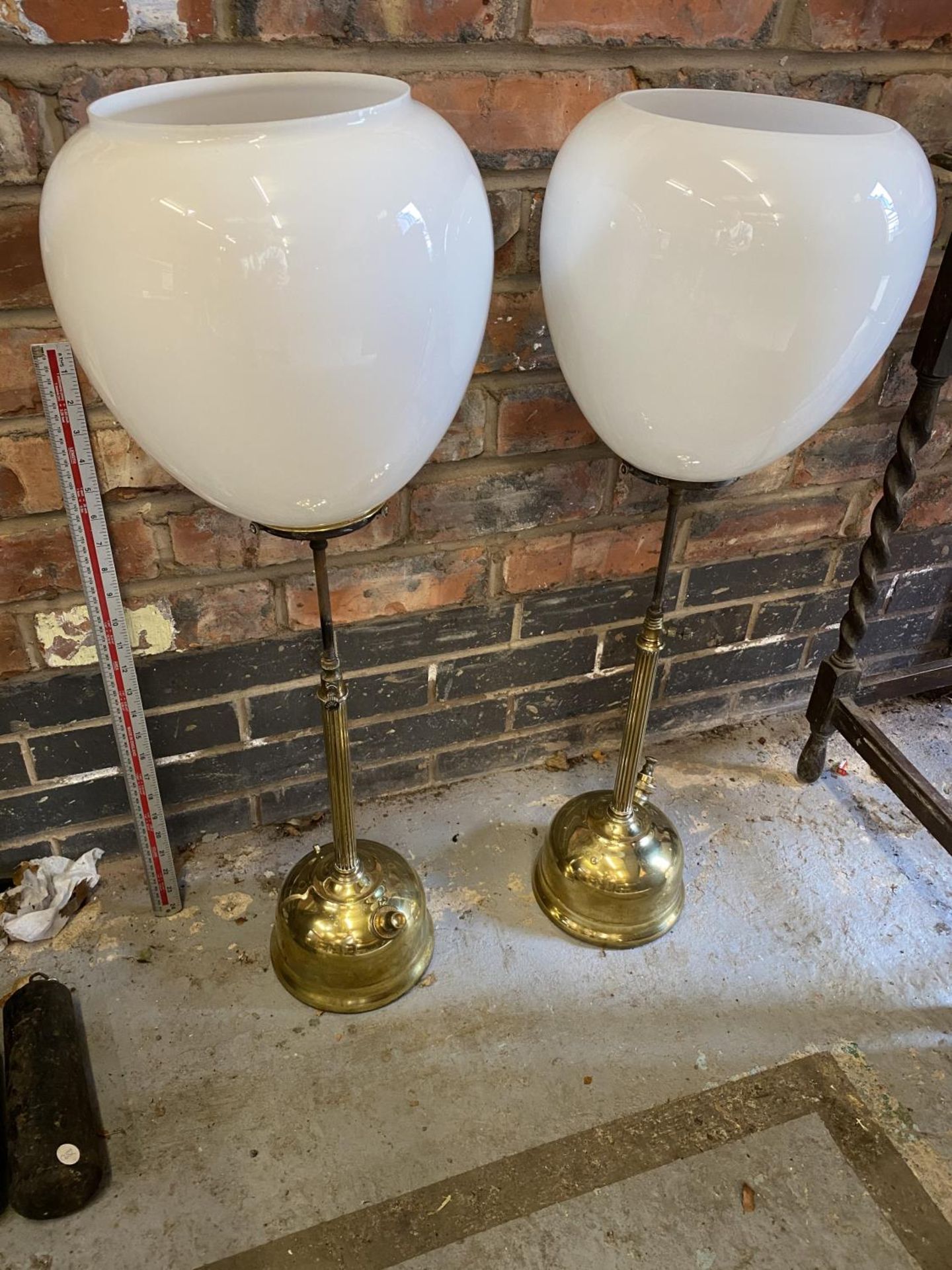 A PAIR OF VICTORIAN BRASS ADJUSTABLE HEIGHT OIL LAMPS WITH WHITE GLASS SHADES