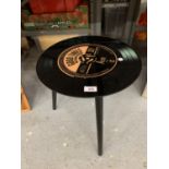 A RETRO THREE LEGGED TABLE WITH A RECORD TOP