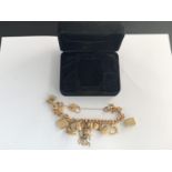 A 9CT GOLD CHARM BRACELET WITH 14 CHARMS, 44.8G