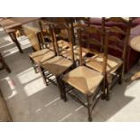 A SET OF SEVEN LANCASHIRE STYLE LADDER BACK RUSH SEATED DINING CHAIRS