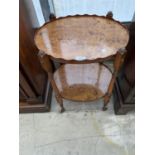 A YEW WOOD VENEERED TWO TIER OCCASIONAL TABLE ON CASTERS