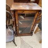 A SMALL WALNUT CABINET WITH TURNED SIDE COLUMNS AND SINGLE GLAZED DOOR