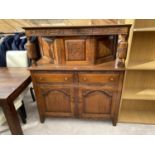 A CARVED OAK COURT CUPBOARD WITH TWO DOORS, TWO DRAWERS AND SINGLE UPPER DOOR