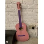 A PINK AND PURPLE ACOUSTIC GUITAR