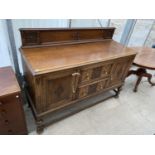 AN EARLY 20TH CENTURY OAK JACOBEAN STYLE SIDEBOARD WITH RAISED BACK AND TURNED FRONT LEGS, 59" WIDE