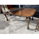 A VICTORIAN MAHOGANY EXTENDING DINING TABLE WITH TWO EXTRA LEAVES ON BALL AND CLAW FEET