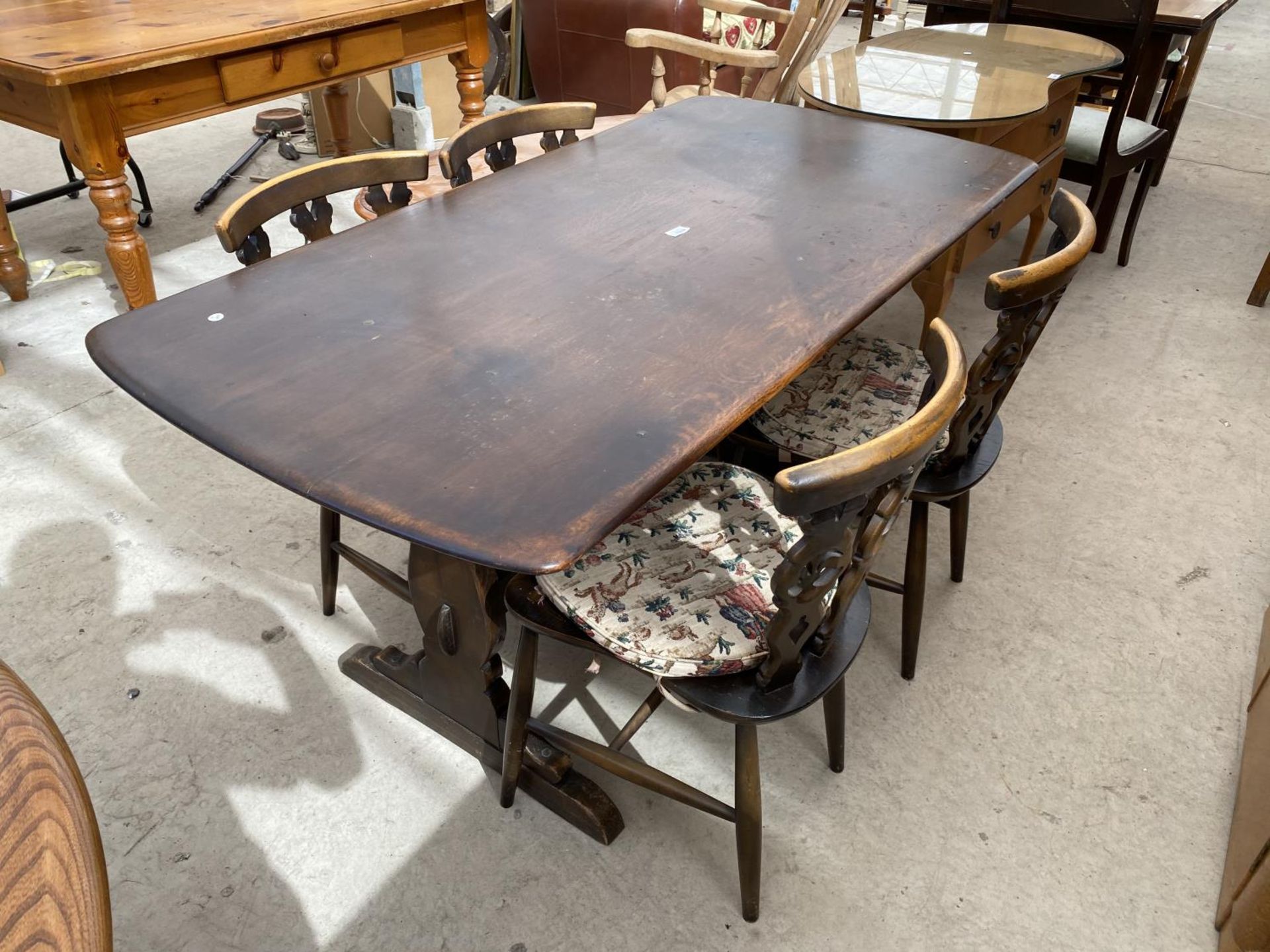 AN ERCOL REFECTORY DINING TABLE AND FOUR CHAIRS