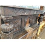 A HEAVILY CARVED OAK COURT CUPBOARD WITH TWO LOWER AND TWO UPPER DRAWERS