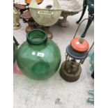 A GREEN GLASS CARBOY AND A VINTAGE PARAFFIN LAMP