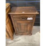A SMALL OAK SIDE CABINET WITH ONE DOOR AND ONE DRAWER