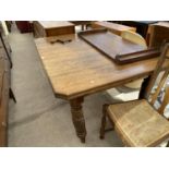 AN EDWARDIAN OAK WIND OUT DINING TABLE WITH CANTED CORNERS, SPARE LEAF AND WINDER 53 INCHES X 42