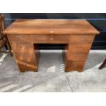 AN OAK TWIN PEDESTAL DESK WITH NINE DRAWERS