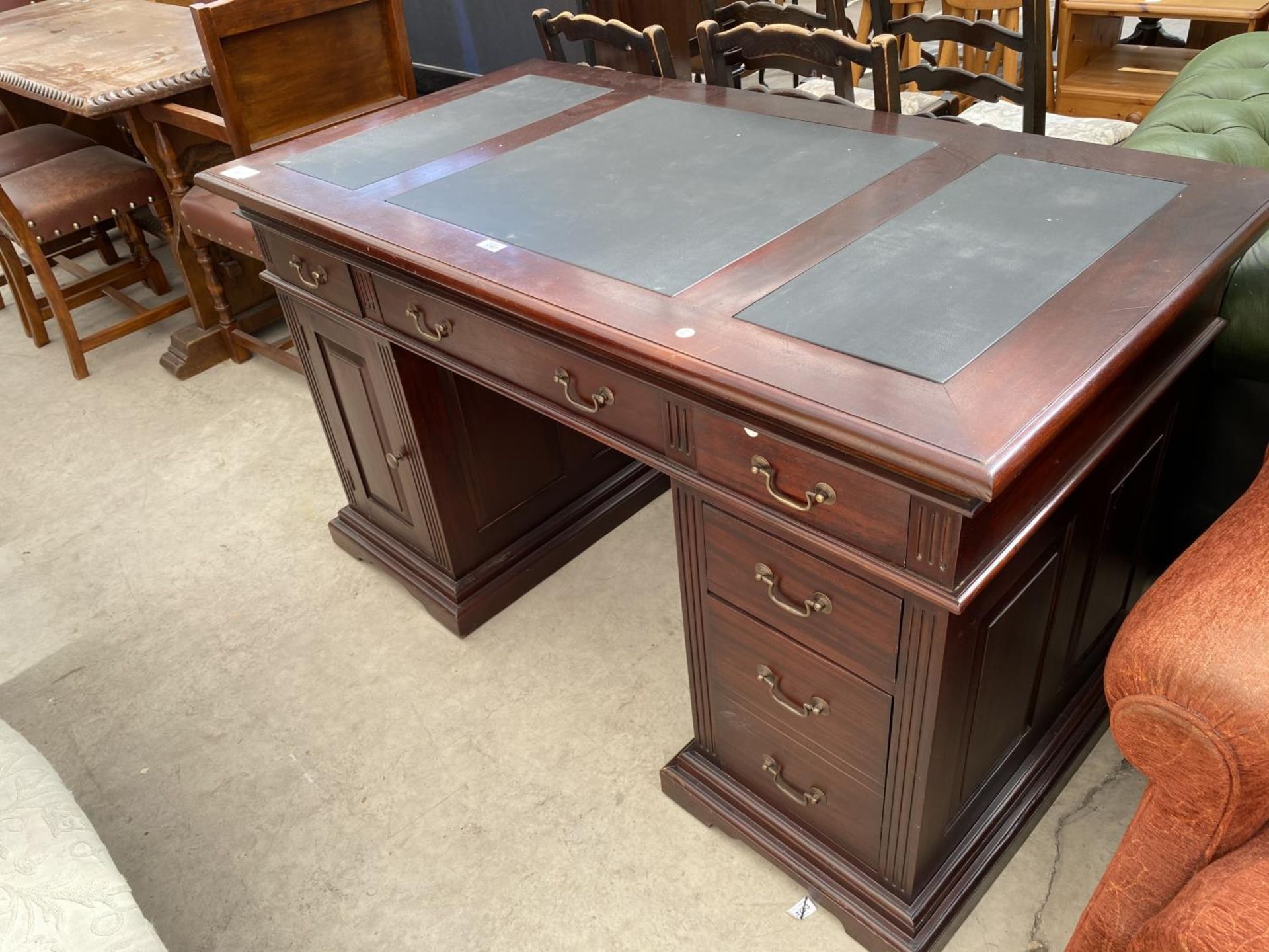 A MAHOGANY TWIN PEDESTAL DESK WITH ONE DOOR, SIX DRAWERS AND INSET LEATHER TOP