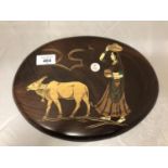 AN OVAL INLAID WOODEN PLAQUE DEPICTING AN INDIAN SCENE