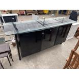 A MODERN BLACK SIDEBOARD WITH THREE DOORS AND GLASS TOP