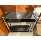 A BLACK GLASS THREE TIER CONSOLE TABLE