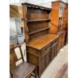 A PRIORY STYLE OAK DRESSER WITH TWO DOORS, TWO DRAWERS AND UPPER PLATE RACK