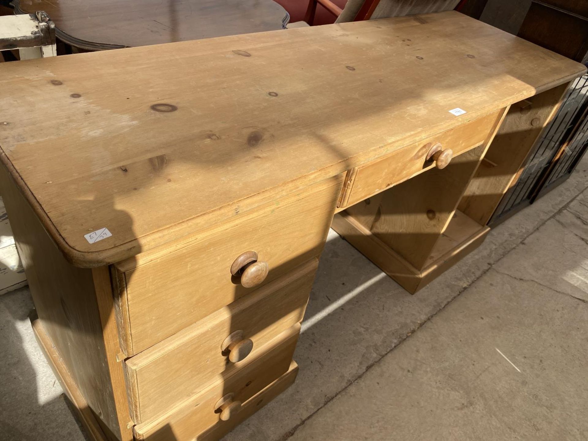 A PINE KNEE HOLE DESK (LACKING DRAWER)