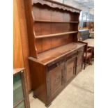 A JACOBEAN STYLE DRESSER WITH THREE DOORS , THREE DRAWERS AND A PLATE RACK