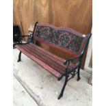 A WOODEN BENCH WITH ORNATE CAST IRON ENDS AND BACK PANEL