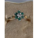 AN 18 CARAT GOLD RING WITH DIAMOND AND GREEN STONES