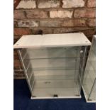 A MODERN WHITE AND GLASS DISPLAY CABINET WITH GLASS DOORS AND SHELVES