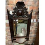 AN ORNATE WOODEN WALL MIRROR