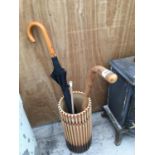 A CERAMIC UMBRELLA/STICK STAND RESEMBLING BAMBOO WITH A WALING STICK AND UMBRELLA