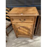 A SMALL OAK SIDE CABINET WITH ONE DOOR AND ONE DRAWER