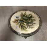 A SILVER PLATED FRAMED CERAMIC PLATE OF WILD FLOWERS TEAPOT STAND