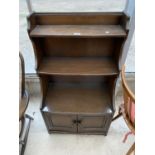 AN ERCOL WATERFALL BOOKCASE WITH CUPBOARDS TO THE BASE, 24" WIDE