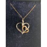 A 9 CARAT GOLD NECKLACE WITH SILVER AND GOLD HEART PENDANT
