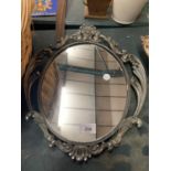 AN OVAL ORNATE HEAVY METAL MIRROR