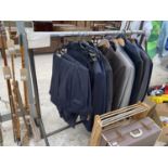 A CLOTHES RAIL AND VARIOUS GENTS JACKETS AND TROUSERS
