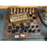 A VINTAGE WOODEN CHESS SET WITH AN ORNATE LEATHER CHESS BOARD