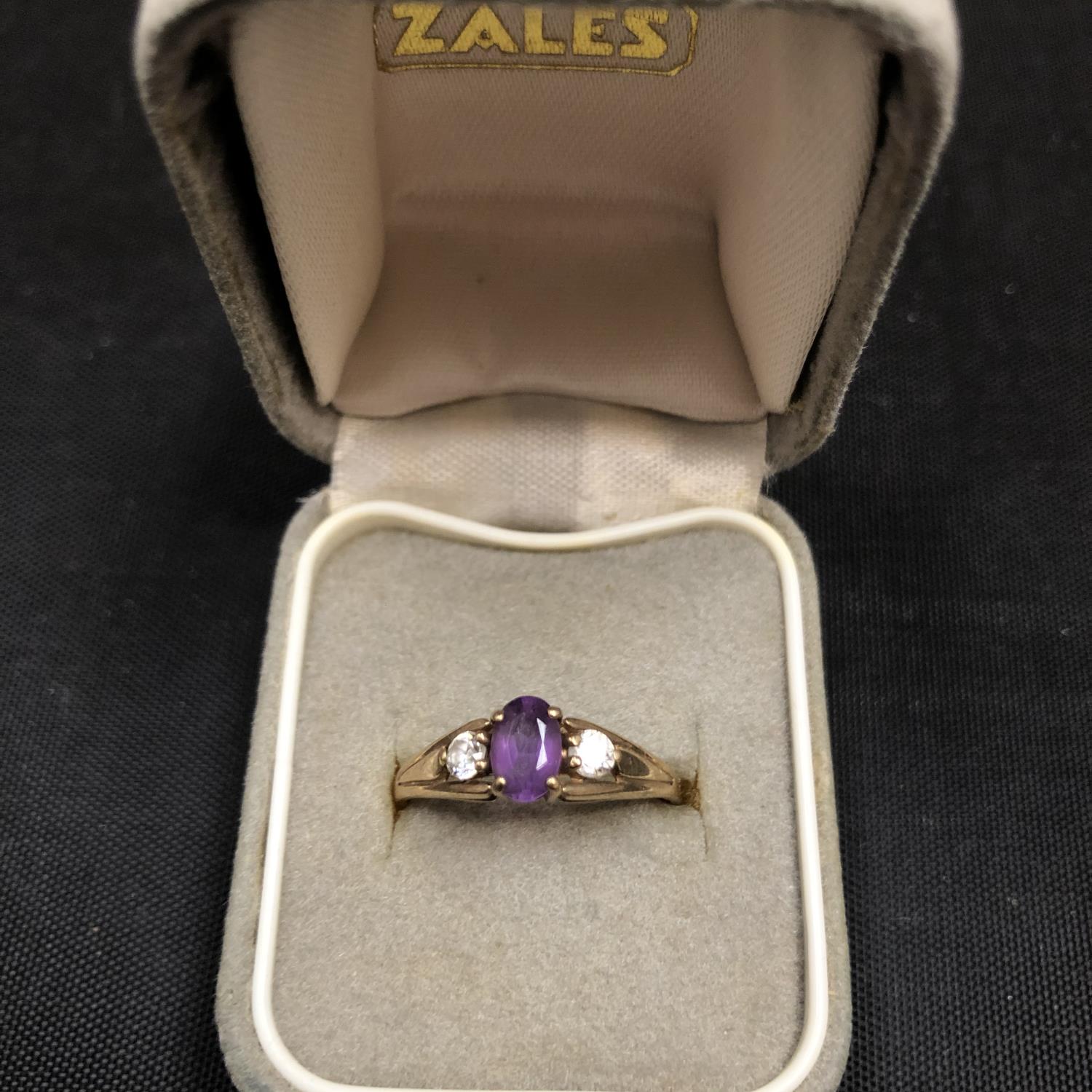 A 9CT GOLD RING SET WITH AN AMETHYST AND TWO CUBIC ZIRCONIA 1.4 GRAMS
