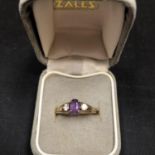 A 9CT GOLD RING SET WITH AN AMETHYST AND TWO CUBIC ZIRCONIA 1.4 GRAMS