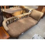 A VICTORIAN OAK FRAMED CHAISE LONGUE ON TURNED LEGS