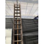 A VINTAGE SET OF EXTENDING WOODEN LADDERS